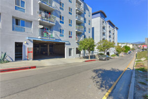 Garage Entrance/Exit from street view. Building exterior balconies and windows above garage